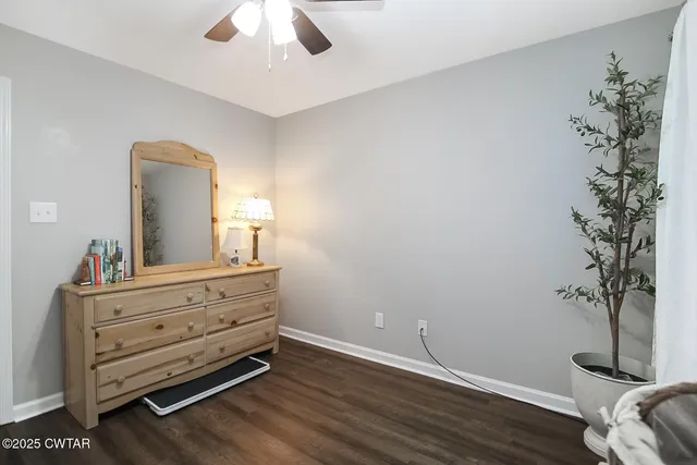 a view of a livingroom with wooden floor and a ceiling fan