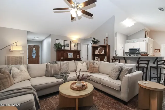 a living room with furniture a rug and a chandelier