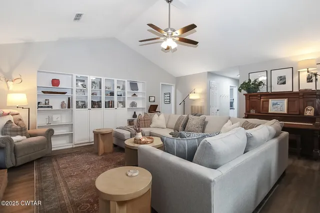 a living room with furniture a chandelier and a dining table