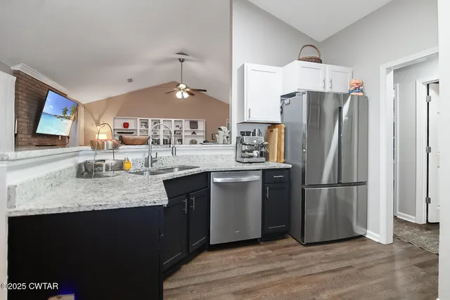 a kitchen with stainless steel appliances granite countertop a refrigerator a sink dishwasher a stove and a refrigerator