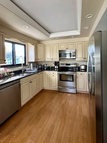a kitchen with stainless steel appliances granite countertop a stove a sink and a refrigerator