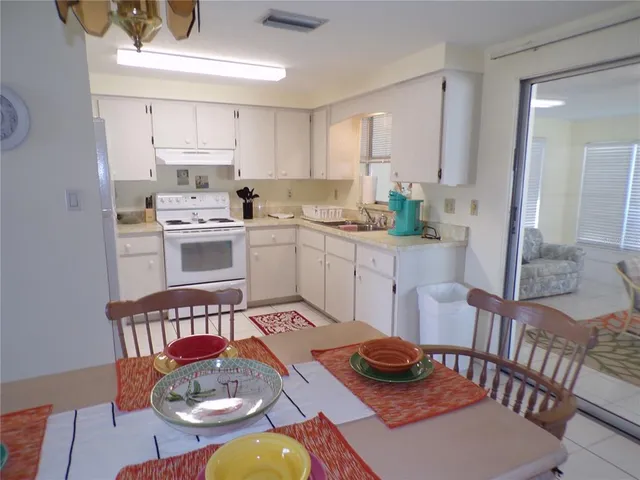 a kitchen with a stove a sink and a dining table