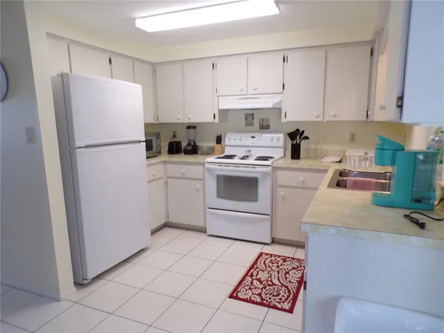 a kitchen with a white stove top oven and white stainless steel appliances
