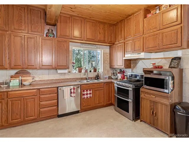 a kitchen with stainless steel appliances granite countertop a sink a stove and cabinets