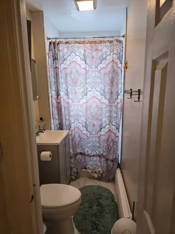 a bathroom with a toilet and a shower curtain