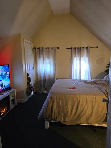 a bed sitting in a bedroom next to a lamp