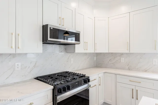 a kitchen with stainless steel appliances white cabinets and a stove