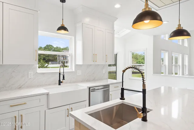 a kitchen with stainless steel appliances granite countertop a sink a stove and a refrigerator