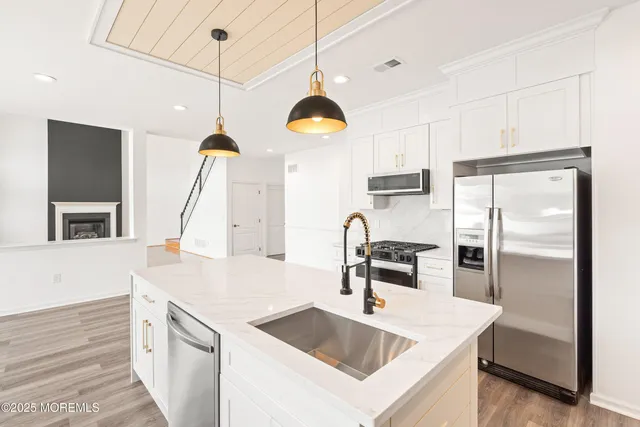 a kitchen with stainless steel appliances a stove a sink a refrigerator and cabinets