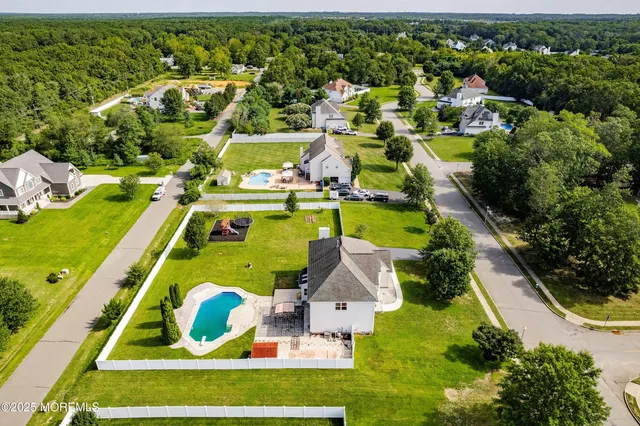 an aerial view of a swimming pool with a yard