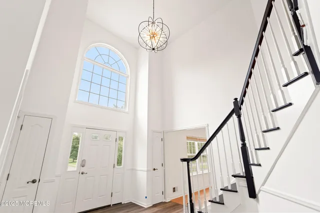 a view of staircase with wooden floor and white walls
