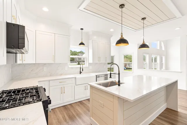 a kitchen with stainless steel appliances kitchen island a sink a stove and a window
