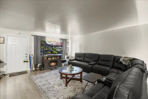 a living room with furniture a flat screen tv and a table