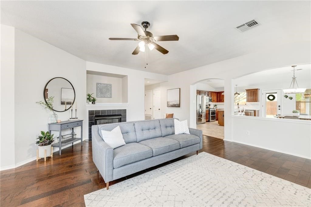 a living room with furniture a fireplace and wooden floor