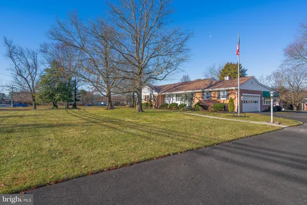 a front view of house with yard and trees in the background