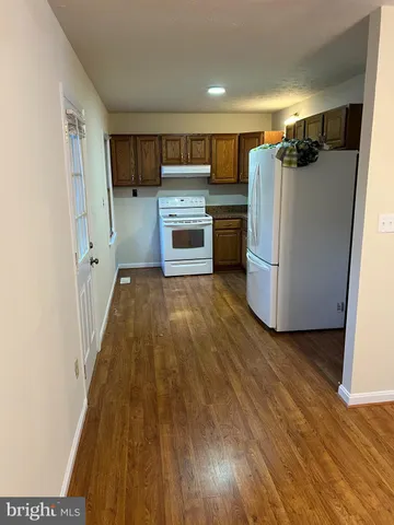 a kitchen with a refrigerator and a stove top oven