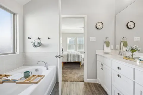 a bathroom with a tub sink and mirror