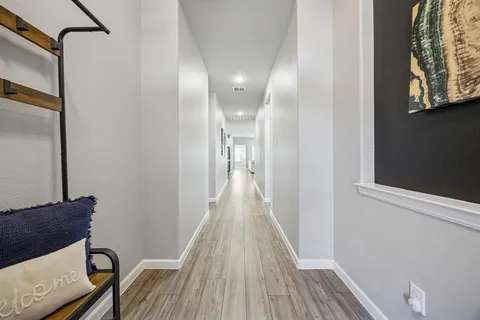 a view of a hallway with wooden floor