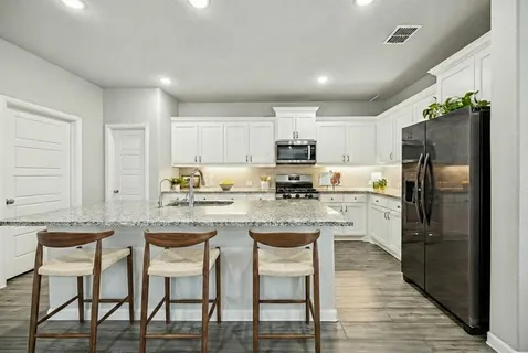 a kitchen with kitchen island granite countertop a counter top space appliances and cabinets