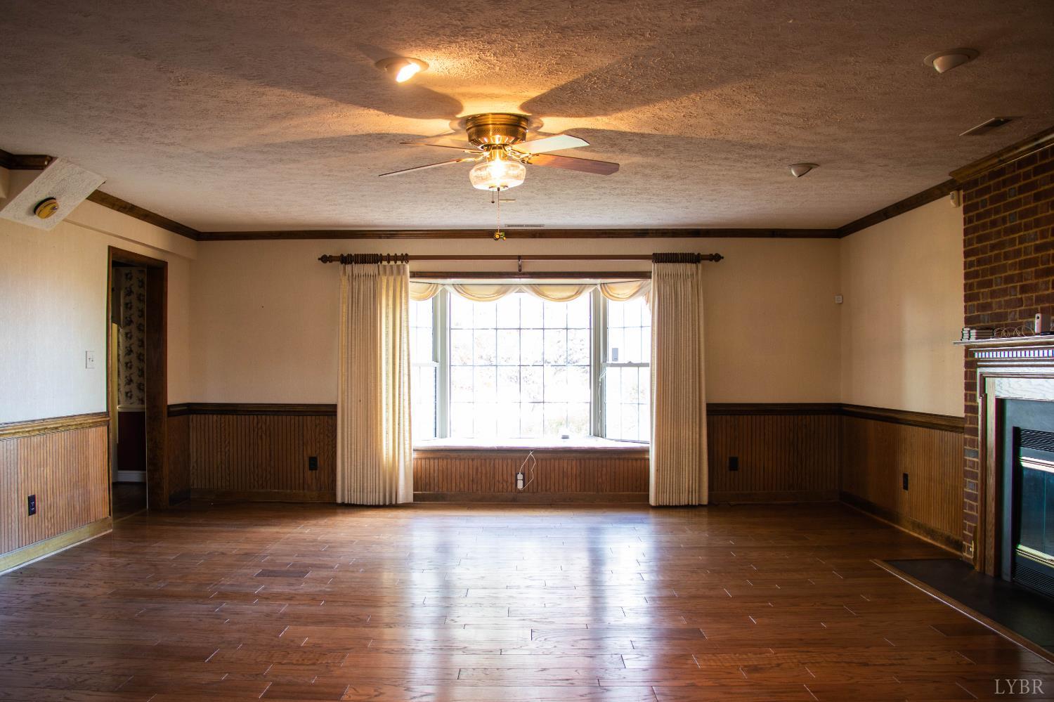 7941 Sugar Hill Road Brookneal, VA 24528 - Photo 11 of 76 a view of an empty room with a window and wooden floor