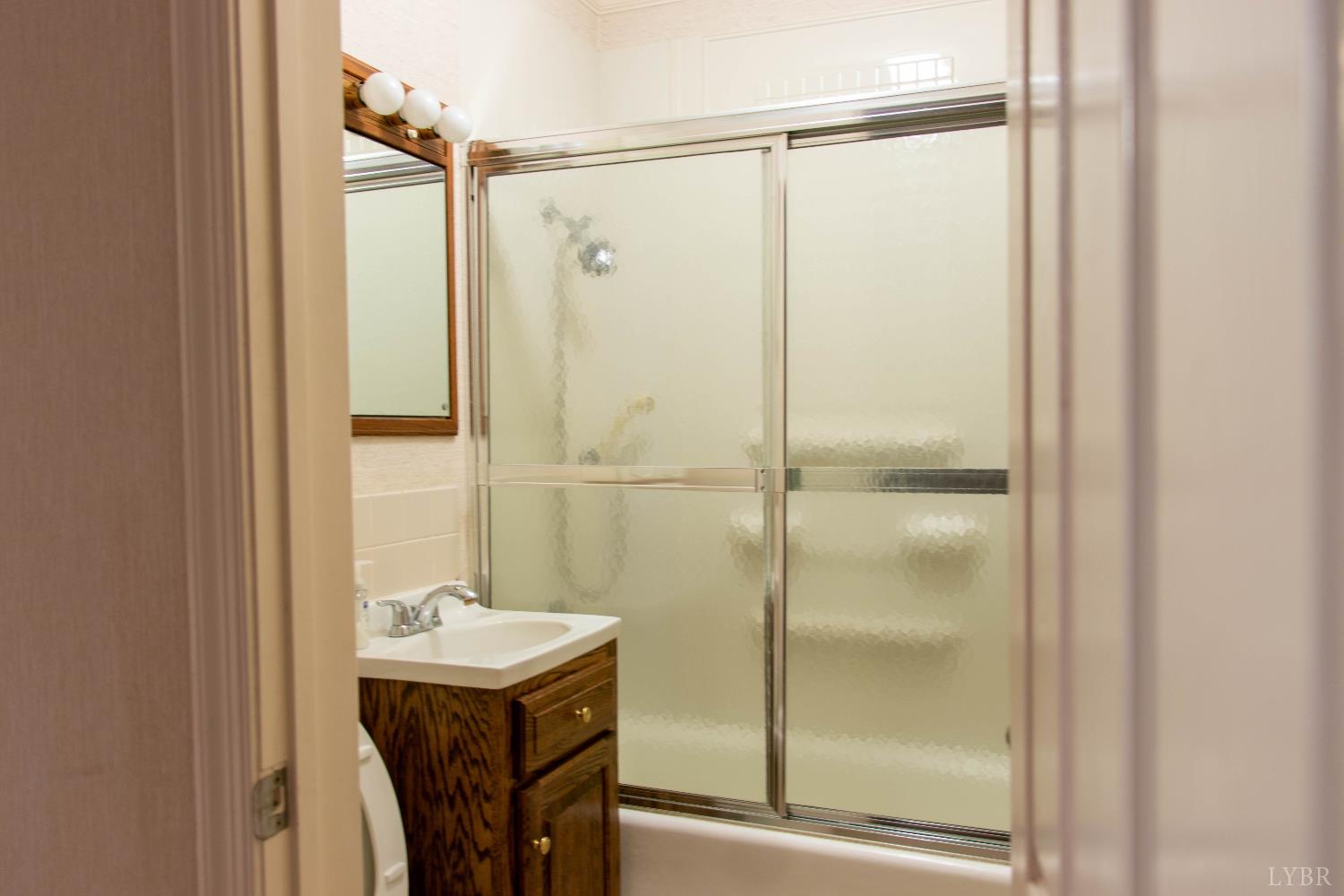 7941 Sugar Hill Road Brookneal, VA 24528 - Photo 22 of 76 a bathroom with a shower sink vanity and a mirror