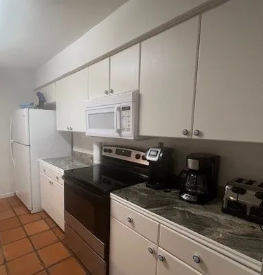 a kitchen with granite countertop a stove and a refrigerator
