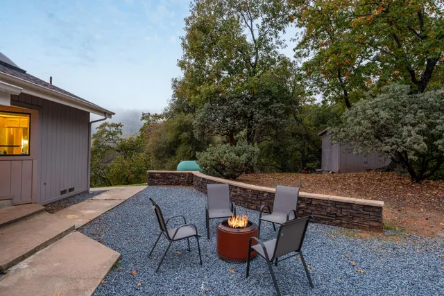 a view of backyard with outdoor seating and trees