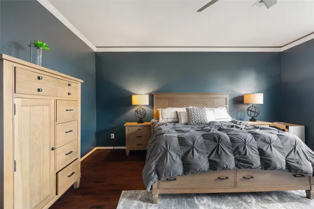 a spacious bedroom with a bed a flat screen tv and a large window