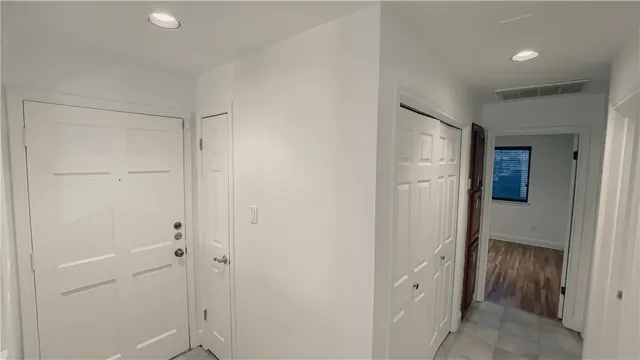 a view of a hallway with closet and wooden door
