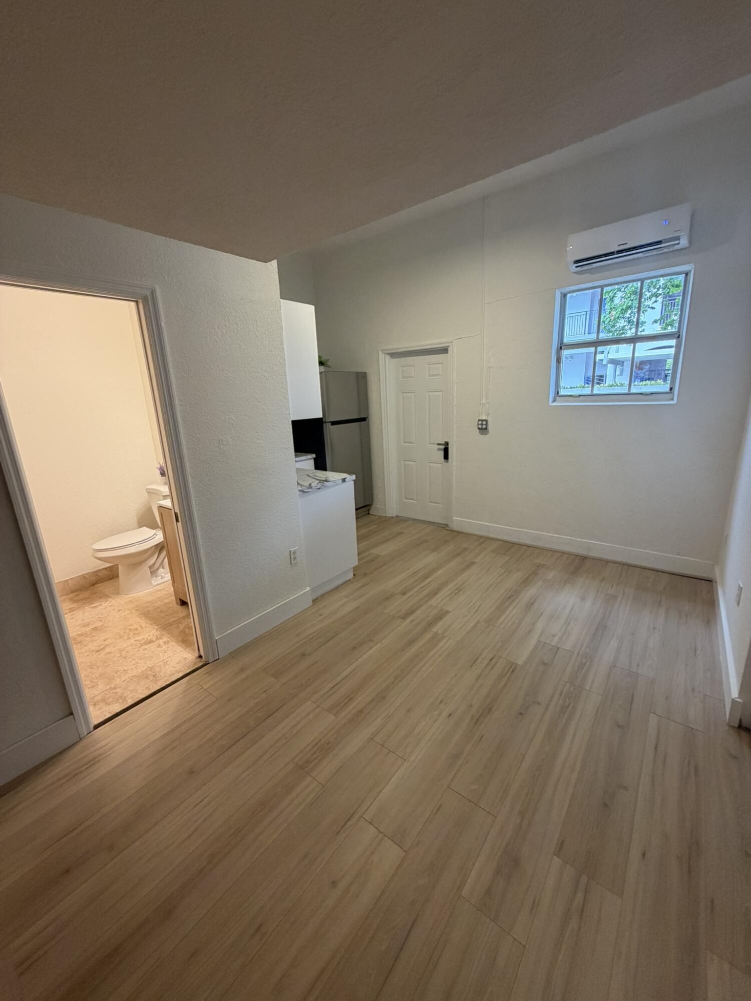 17296 Northwest 88th Court, Unit STUDIO Hialeah, FL 33018 - Photo 2 of 12 wooden floor in an empty room with a window