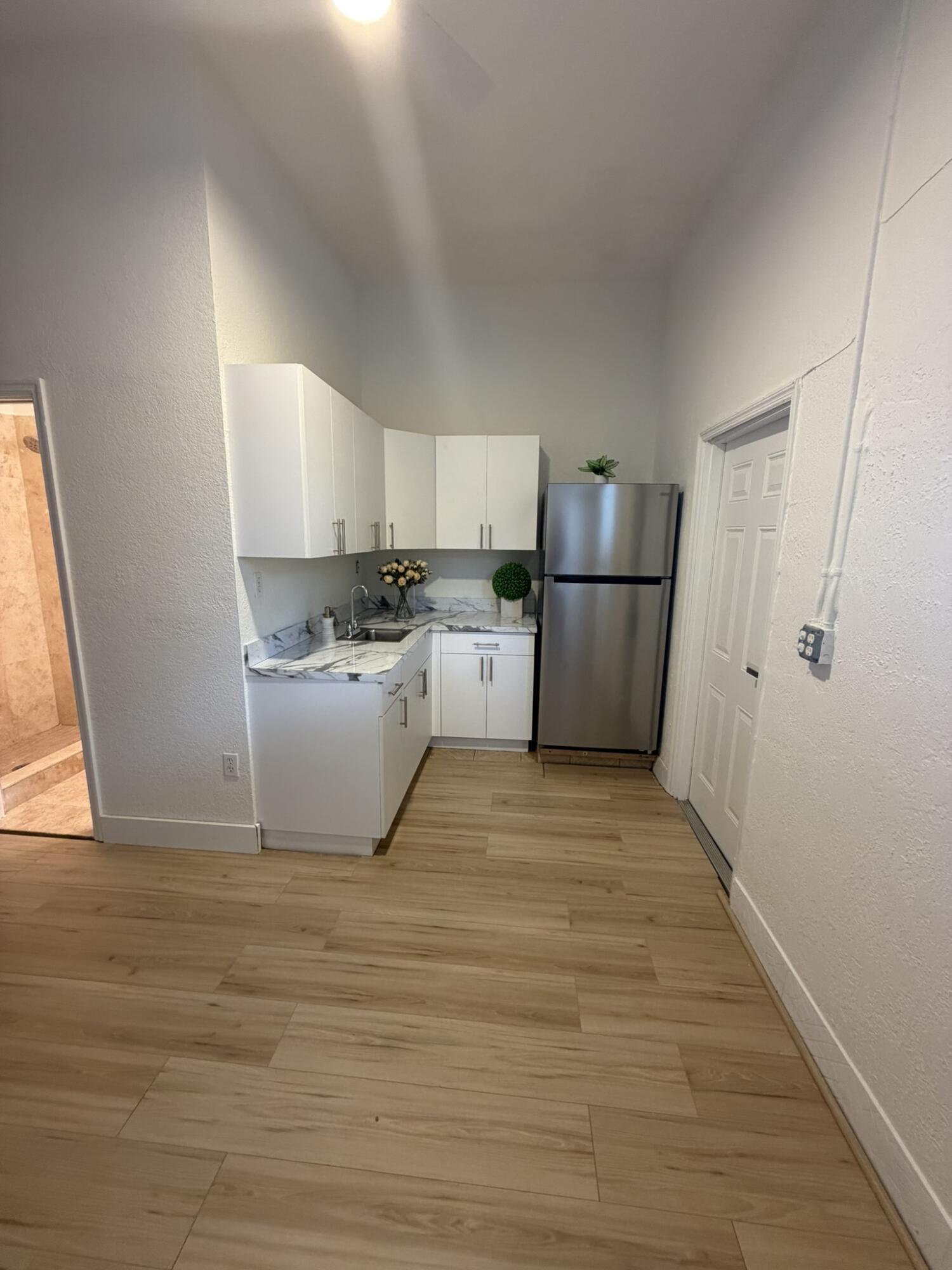 17296 Northwest 88th Court, Unit STUDIO Hialeah, FL 33018 - Photo 3 of 12 a view of a kitchen with a sink dishwasher and a refrigerator
