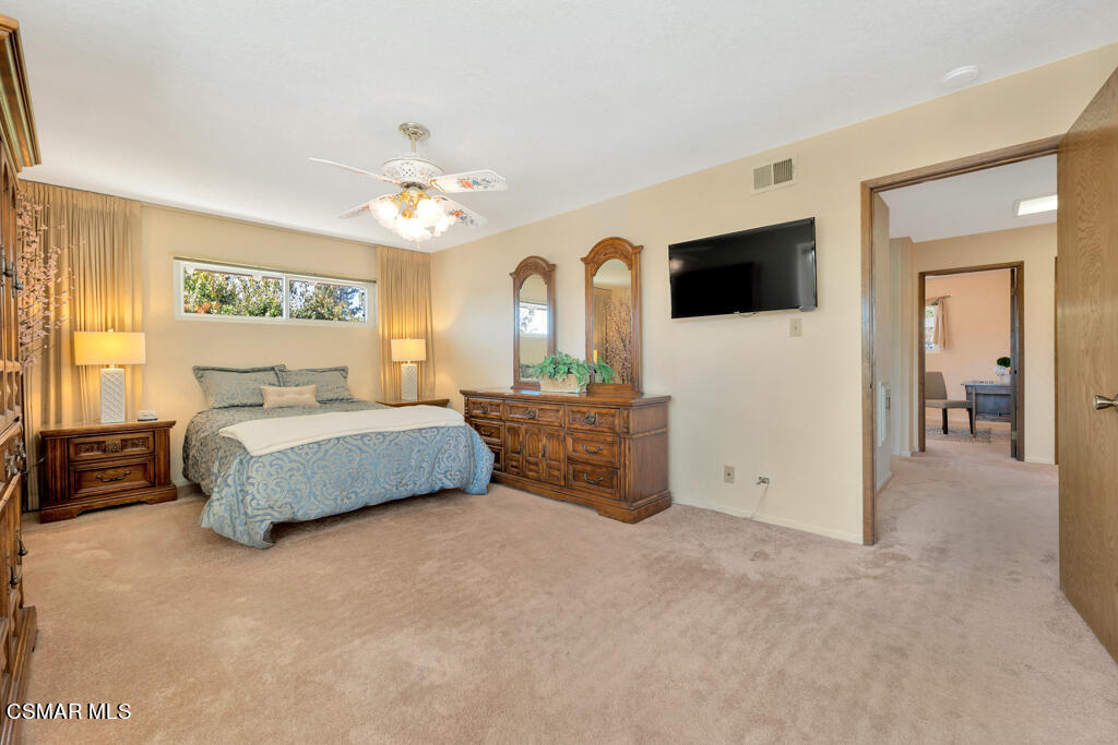 4135 Springfield Street Simi Valley, CA 93063 - Photo 5 of 41 a bedroom with a large bed a flat tv screen and a chandelier