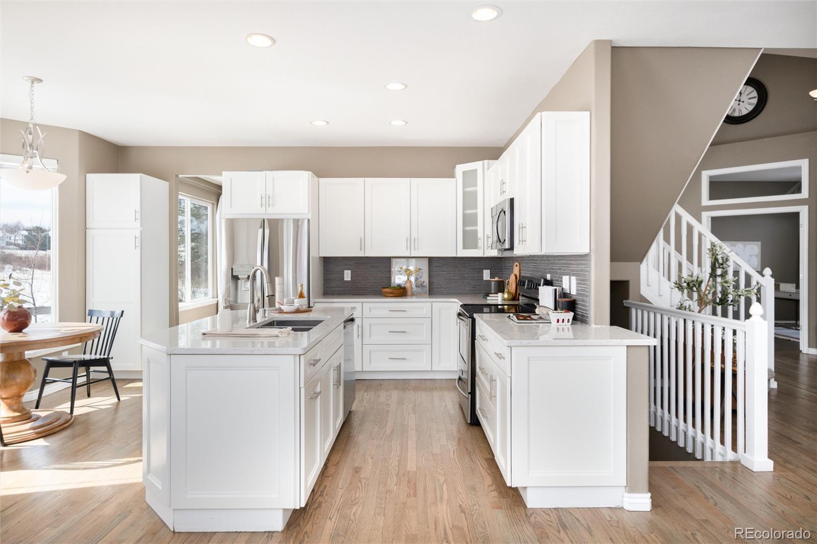 9486 South Autumn Ash Place Highlands Ranch, CO 80126 - Photo 12 of 50 a kitchen with white cabinets and sink