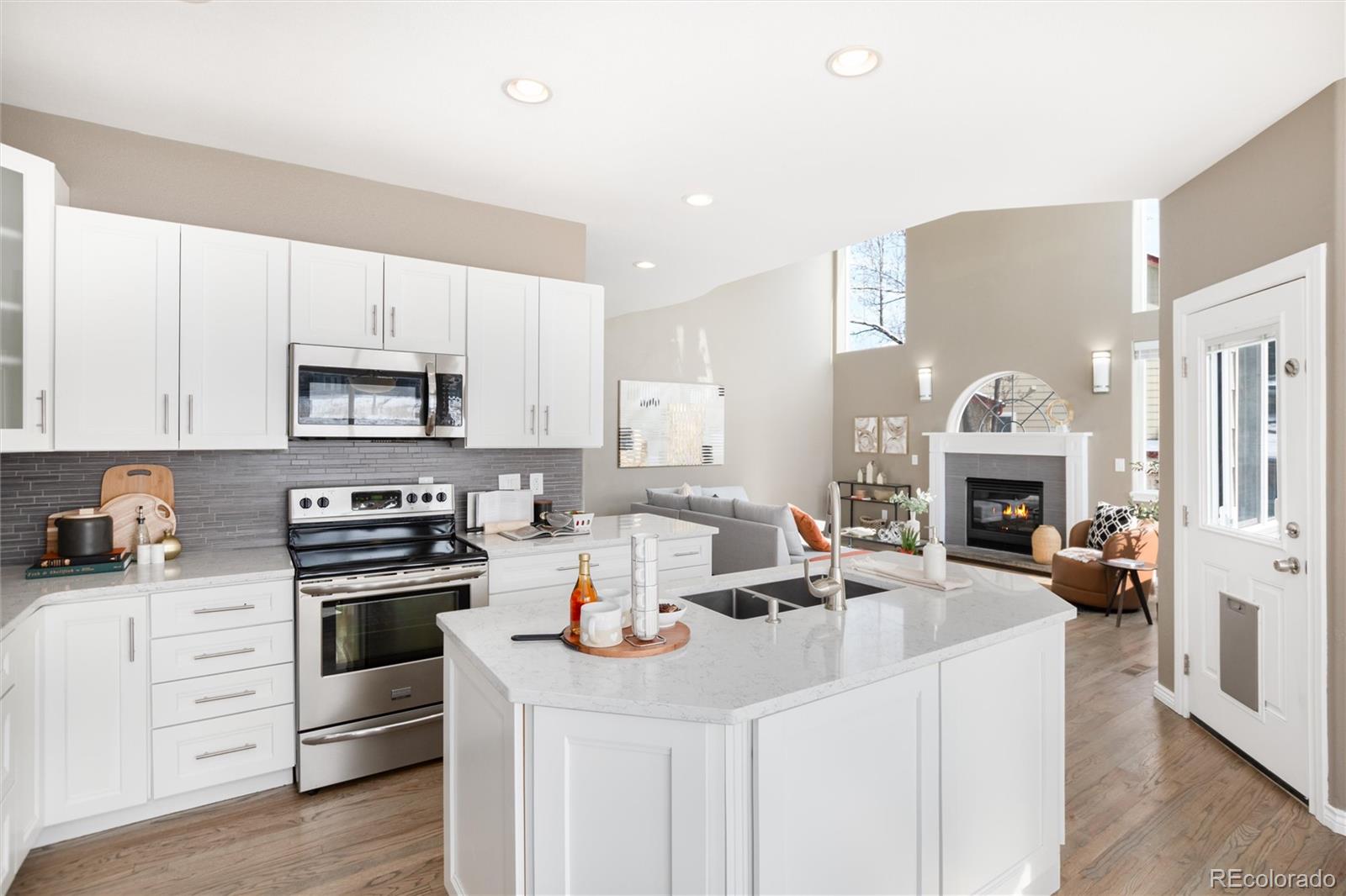 9486 South Autumn Ash Place Highlands Ranch, CO 80126 - Photo 15 of 50 a kitchen with a stove and white cabinets