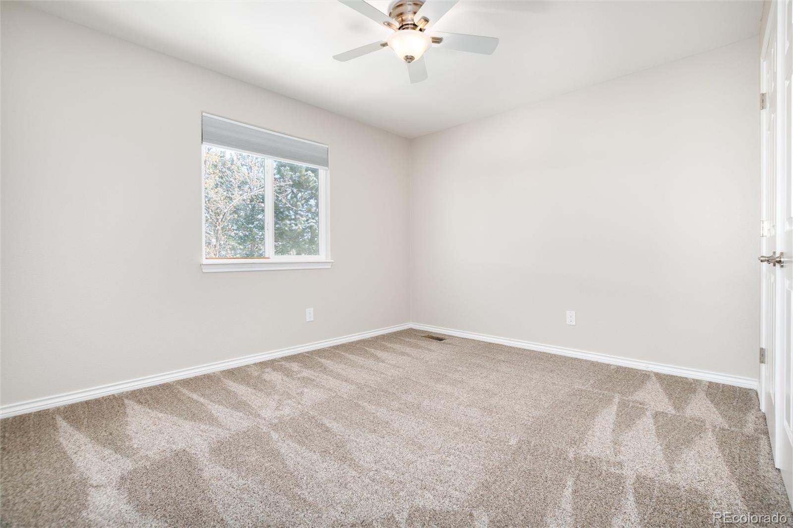 9486 South Autumn Ash Place Highlands Ranch, CO 80126 - Photo 35 of 50 an empty room with a chandelier fan and windows