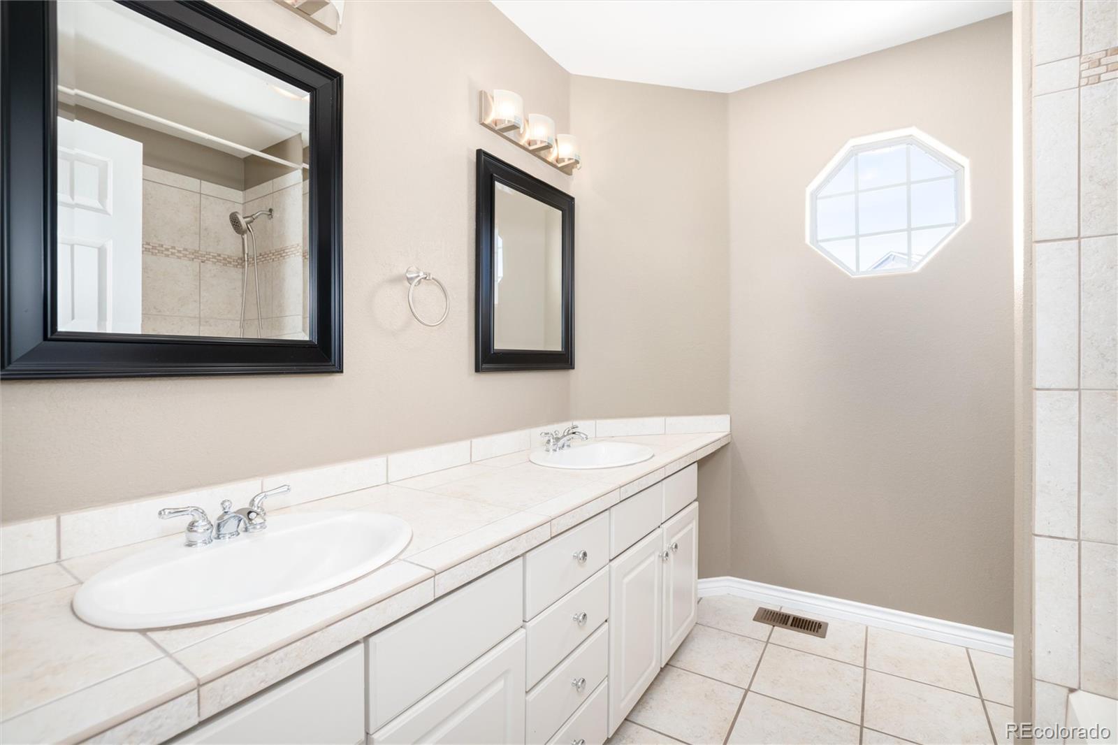 9486 South Autumn Ash Place Highlands Ranch, CO 80126 - Photo 36 of 50 a bathroom with double vanity sink and a mirror