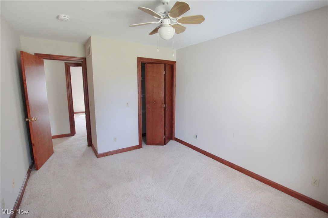 1031 Georgetown Road Salem, OH 44460 - Photo 16 of 31 Unfurnished bedroom featuring baseboards, a ceiling fan, light carpet, and a closet