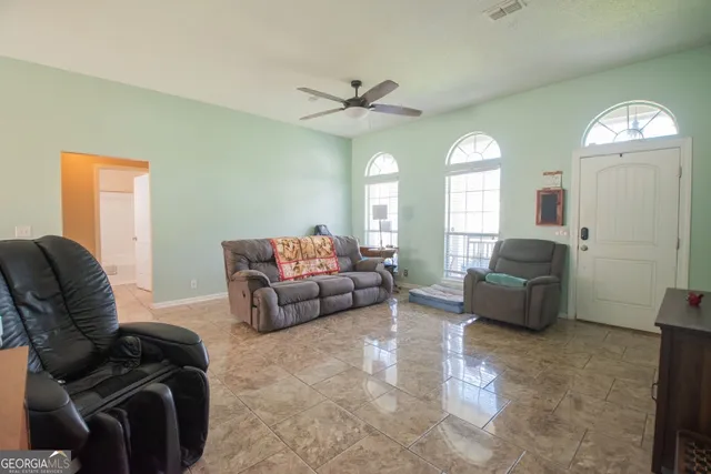 a kitchen with stainless steel appliances granite countertop a refrigerator a stove a sink a dining table and chairs with wooden floor