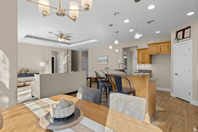 1570 South Rio Virgin Drive Washington, UT 84780 - Photo 22 of 71 Dining space featuring a ceiling fan, light wood-type flooring, hanging lights, and a raised ceiling