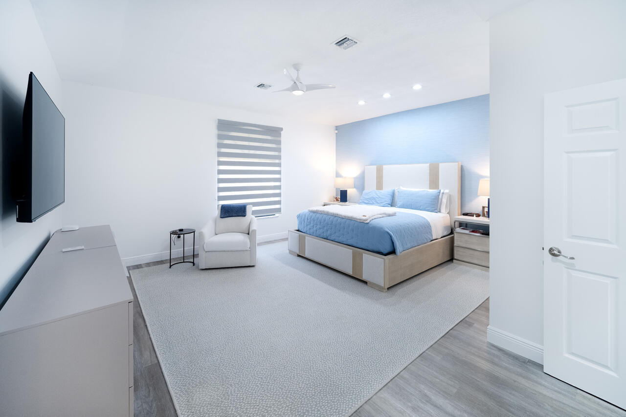 5809 Northwest 21st Way Boca Raton, FL 33496 - Photo 17 of 59 a spacious bedroom with a bed and a flat screen tv