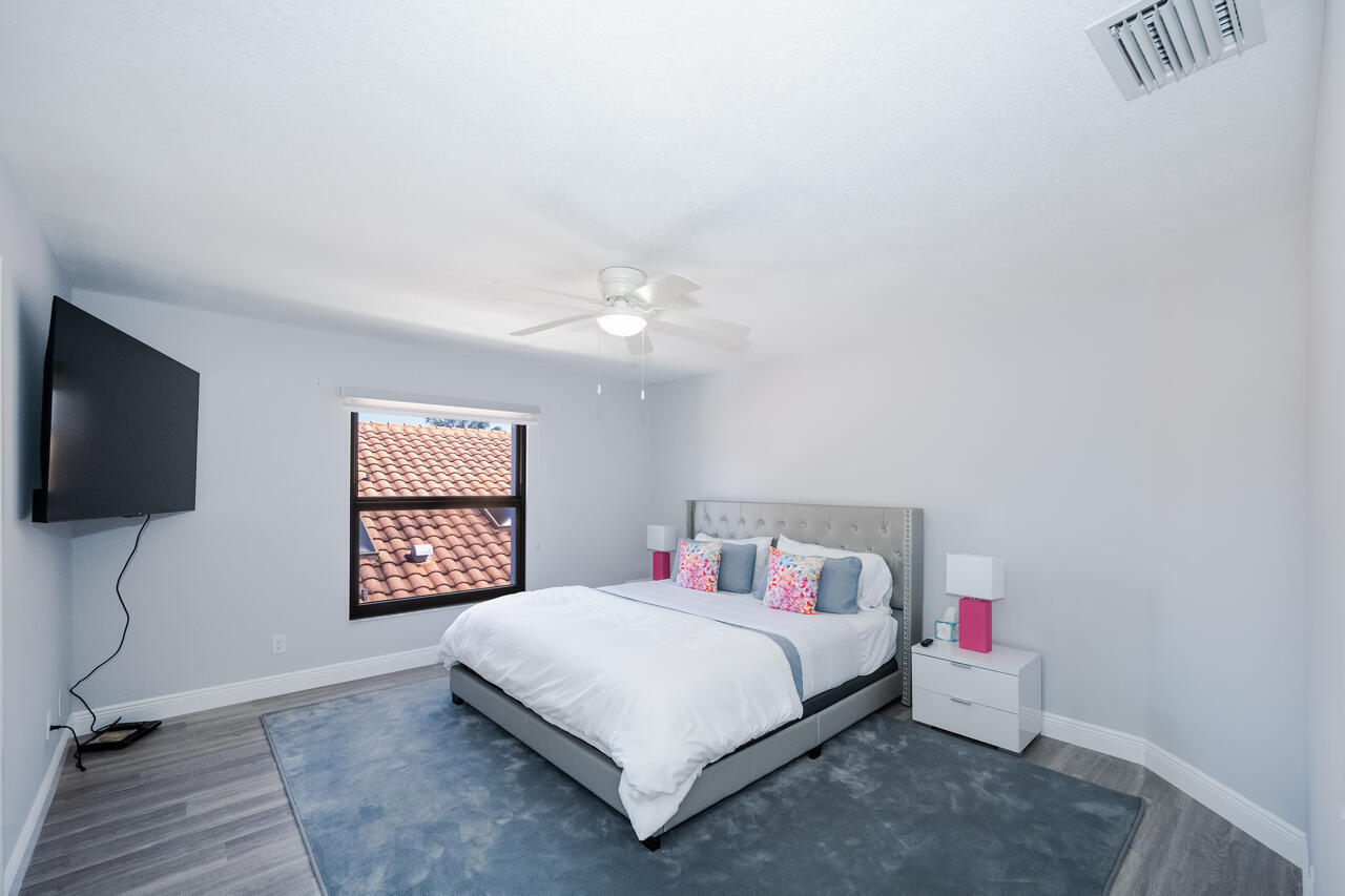 5809 Northwest 21st Way Boca Raton, FL 33496 - Photo 27 of 59 a bedroom with a bed and a flat screen tv
