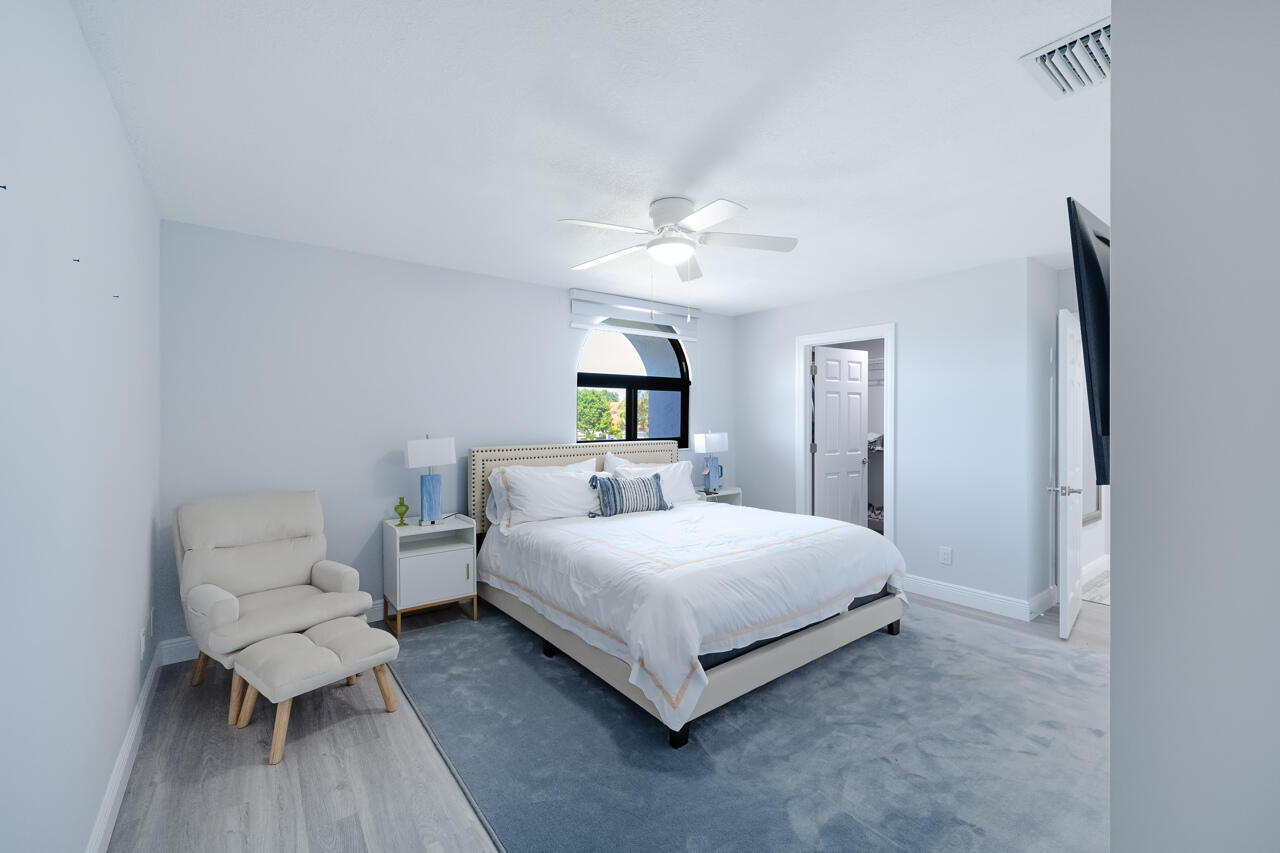 5809 Northwest 21st Way Boca Raton, FL 33496 - Photo 30 of 59 a bedroom with a bed and a chandelier