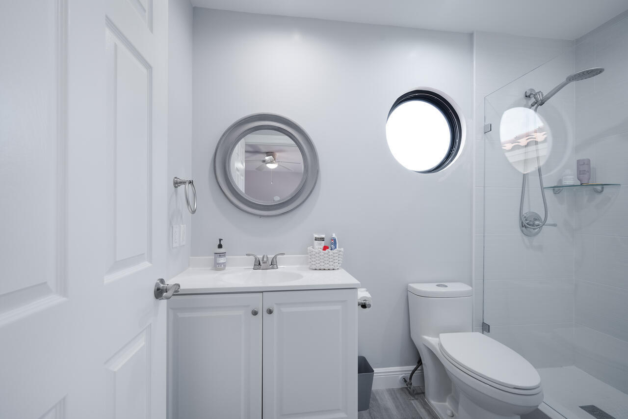 5809 Northwest 21st Way Boca Raton, FL 33496 - Photo 33 of 59 a bathroom with a toilet a sink and a mirror