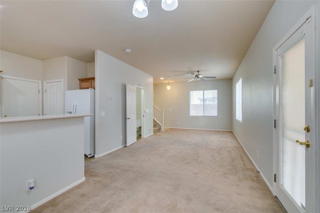8937 Caledon Ridge Court Las Vegas, NV 89149 - Photo 18 of 43 A spacious common area with plush carpeting flows into a functional kitchen space.