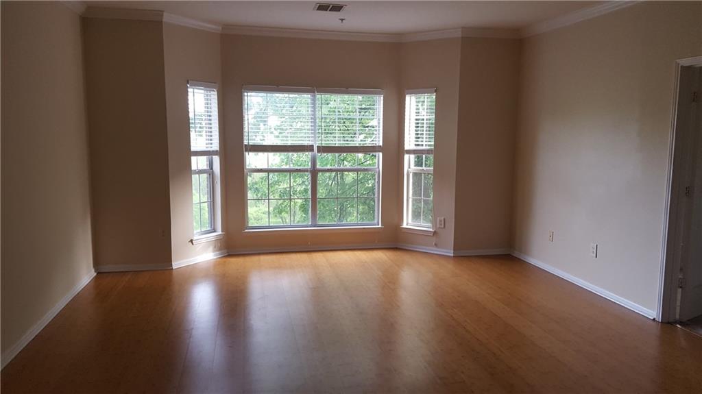 5641 Roswell Road, Unit 106 Atlanta, GA 30342 - Photo 2 of 5 a view of an empty room with wooden floor and a window