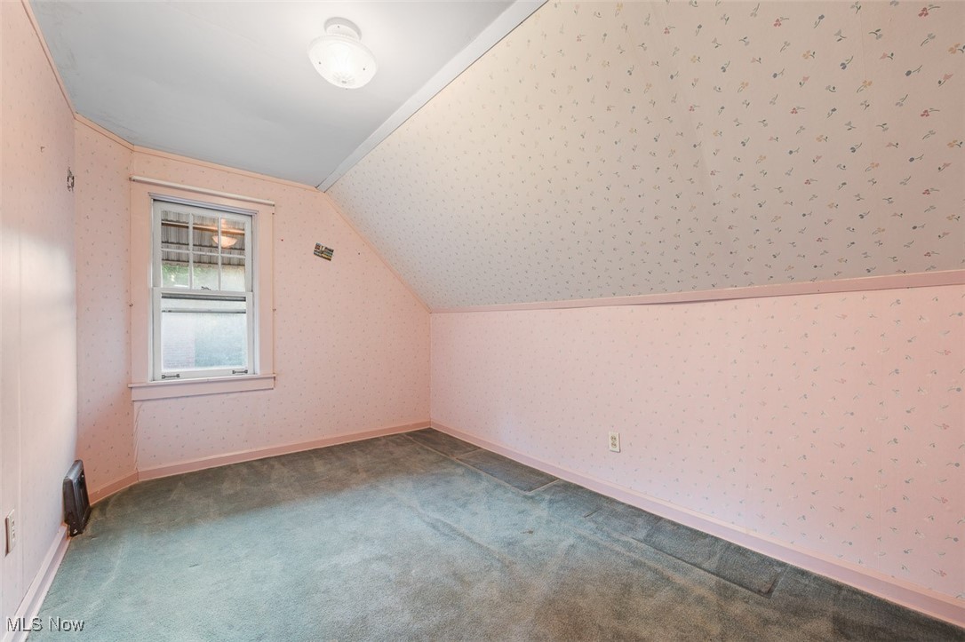 256 Everhard Road Southwest North Canton, OH 44709 - Photo 29 of 45 Additional living space with wallpapered walls, carpet floors, and vaulted ceiling