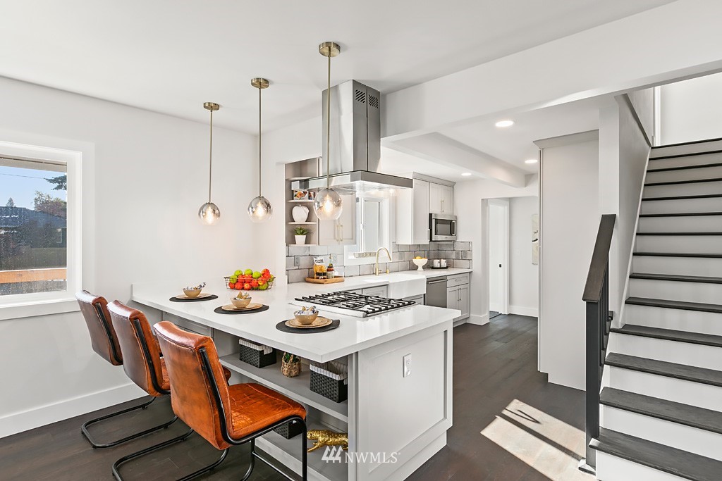 4906 Southwest Hinds Street Seattle, WA 98116 - Photo 27 of 40 a kitchen with a table chairs stove and wooden floor