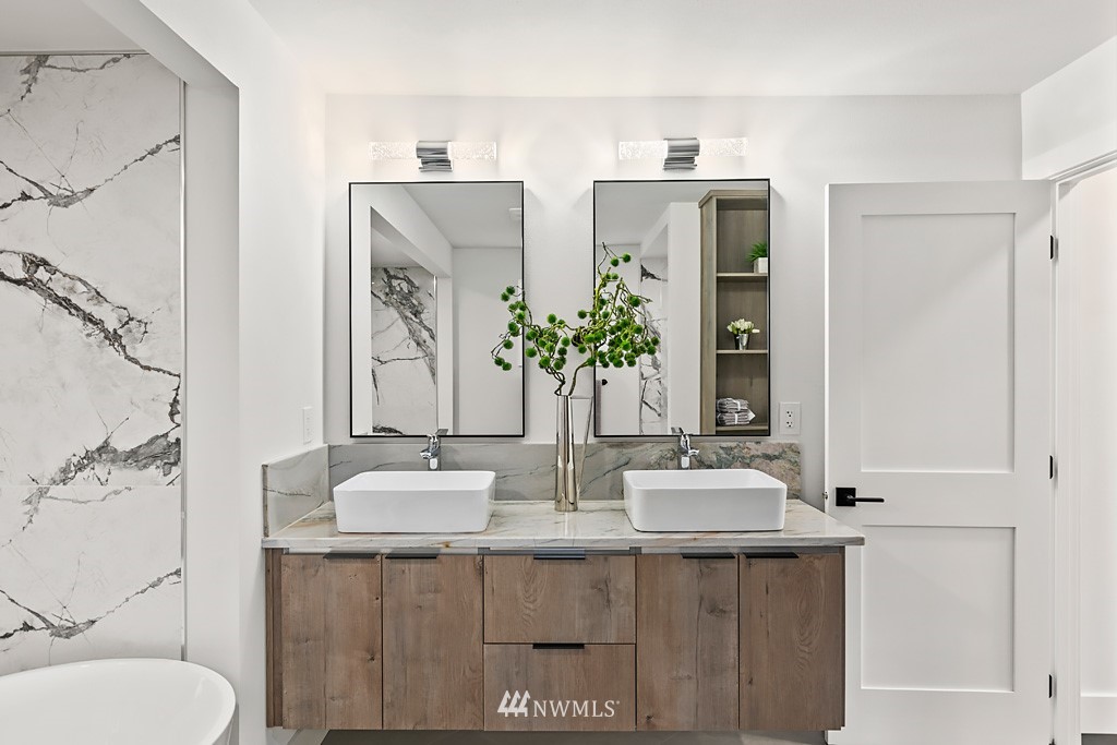 4906 Southwest Hinds Street Seattle, WA 98116 - Photo 10 of 40 a bathroom with double vanity sinks a toilet a mirror and shower