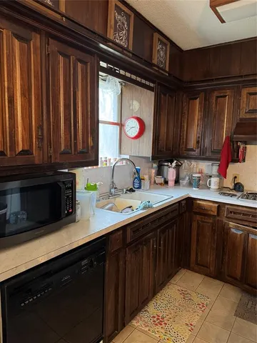 a kitchen with stainless steel appliances granite countertop a sink dishwasher stove and cabinets