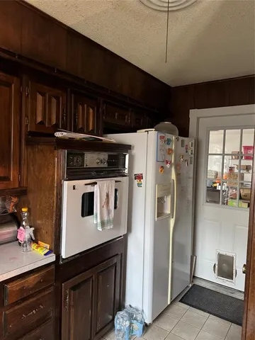 a kitchen with stainless steel appliances granite countertop a refrigerator a stove and a sink with wooden floor